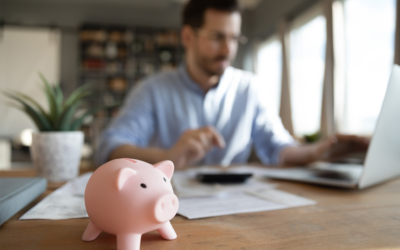 Man with piggy bank next to him