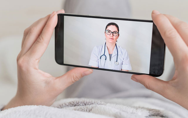 Hands holding phone with doctor on screen